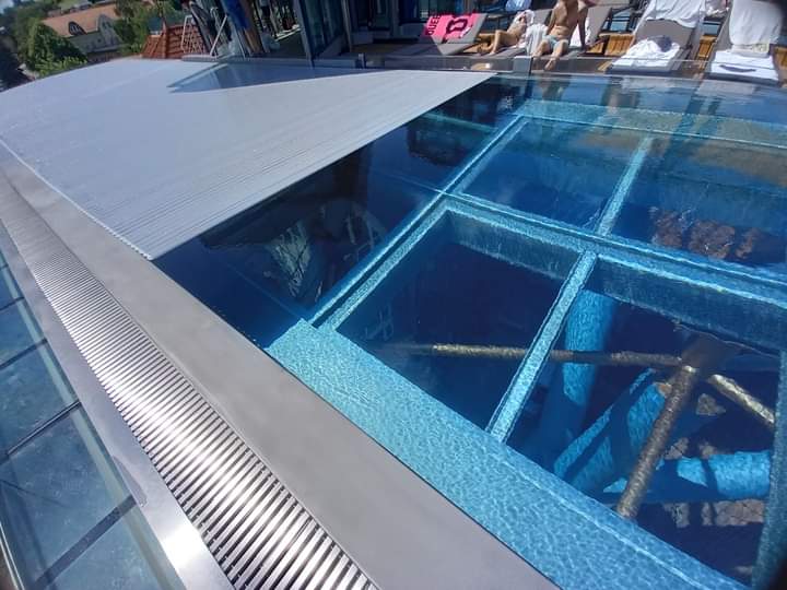 Kilátás lefelé az átlátszó aljú, plexi nemesacél medencéből a MenDan Hotelben